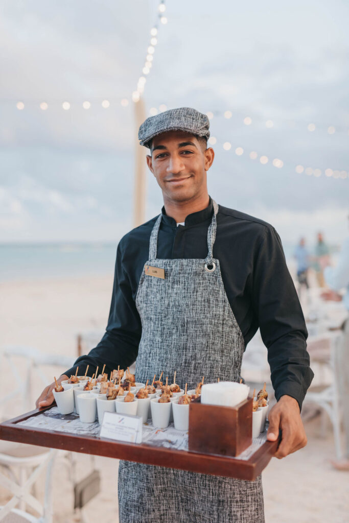Staff member of the Hyatt Ziva resort holding a tray of appetizers at wedding cocktail hour
