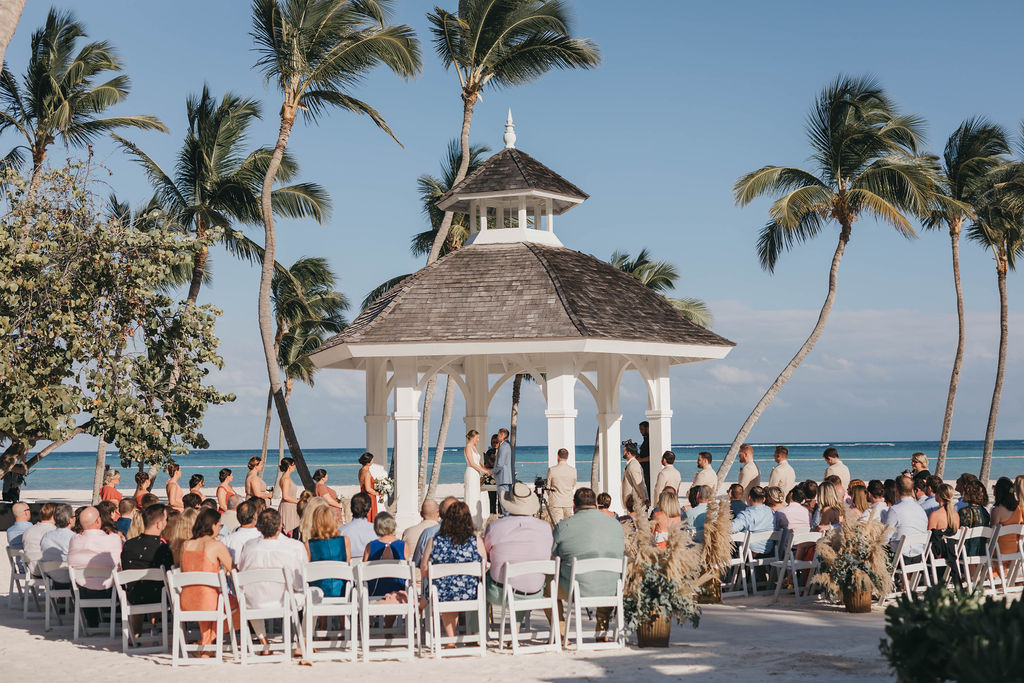 100 wedding guests sitting in white chairs for beach front wedding ceremony in the Dominican Republic | Lauren E. Bliss Destination Wedding Photography