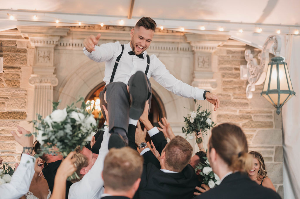 Groom crowd surfs above wedding guests during wedding reception at the Greystone Hall venue in West Chester PA