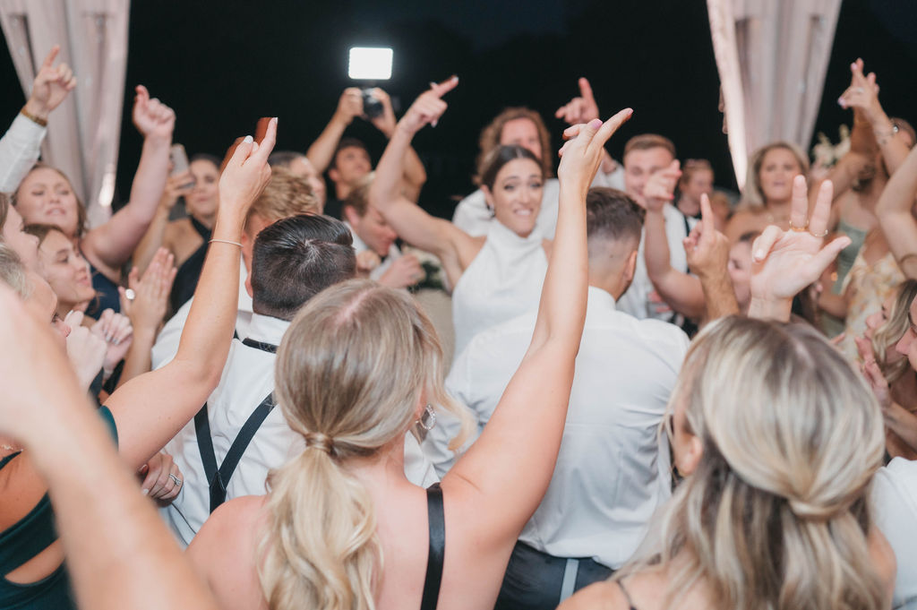 Wedding guests jumping up and down with their hands in the air during wedding reception at the Greystone Hall venue in West Chester PA