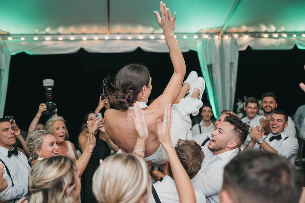 Bride crowd surfing above wedding guests at Greystone Hall wedding venue in West Chester PA 