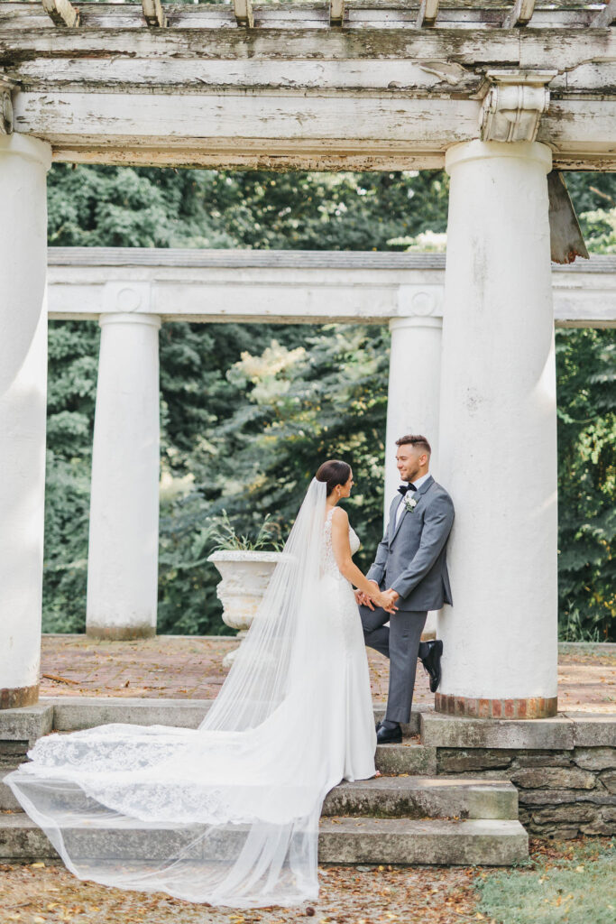Bride and groom under pergola for their wedding day first look session at Greystone Hall | Lauren E. Bliss Photography