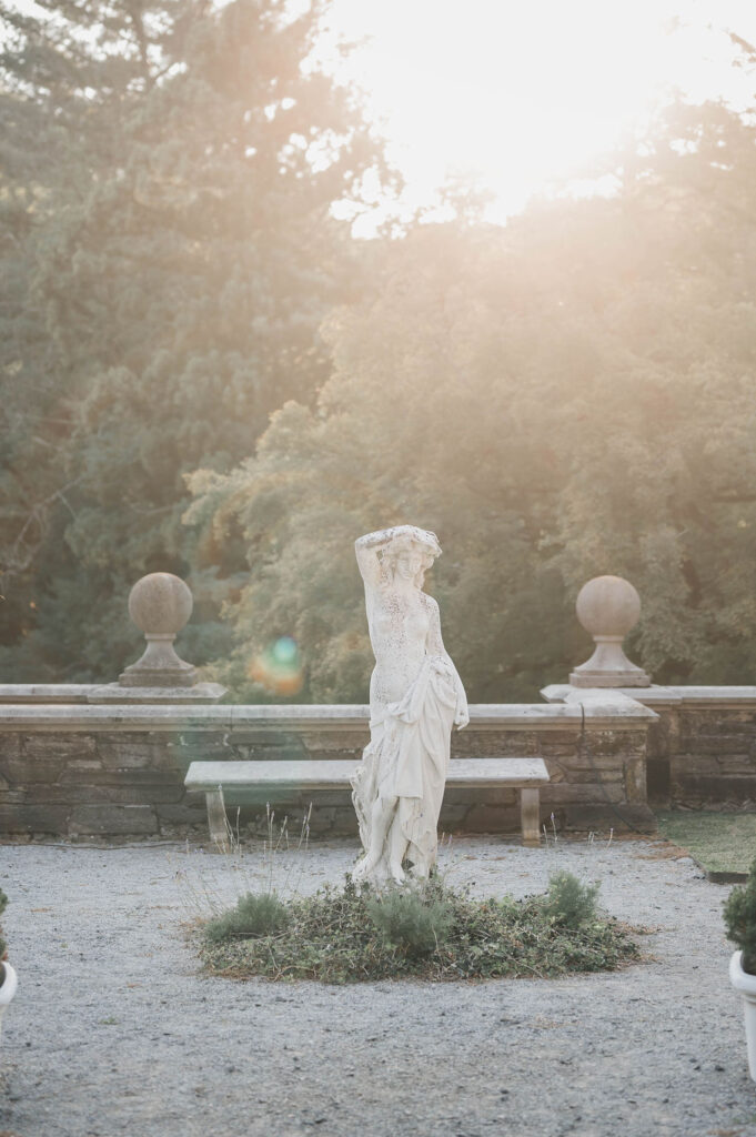 English Renaissance era marble statue of a woman in the center of a garden