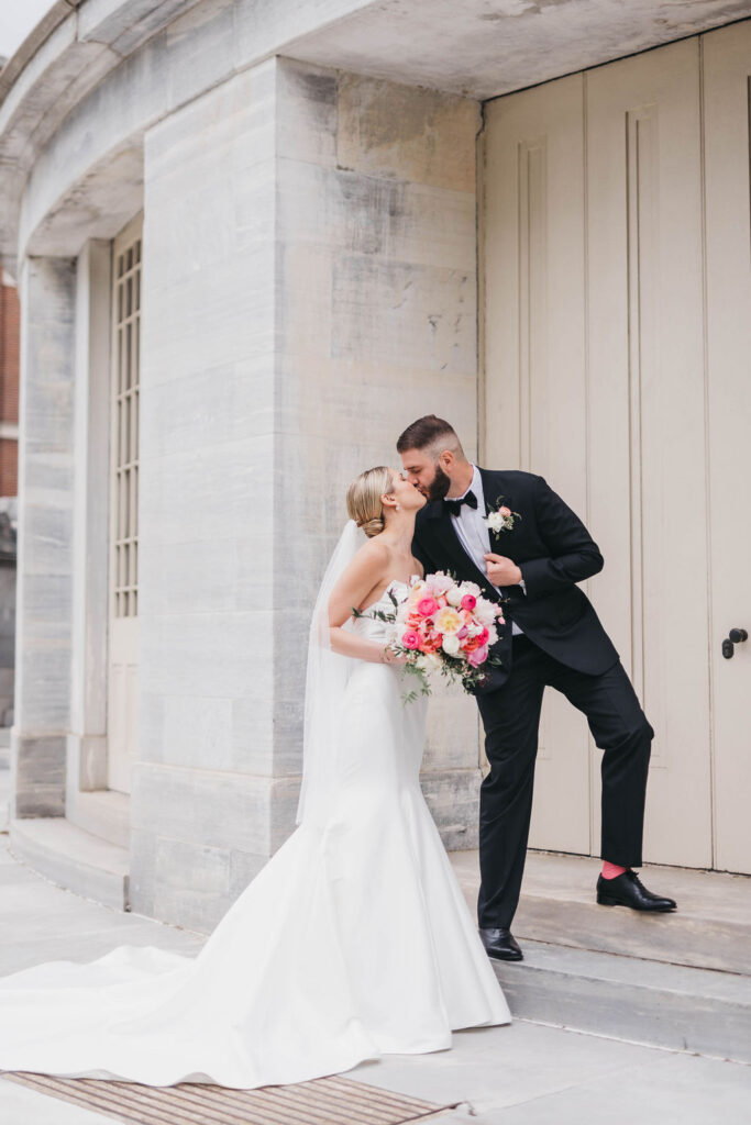 Bride and groom kiss on the steps of the Merchant's Exchange Building
