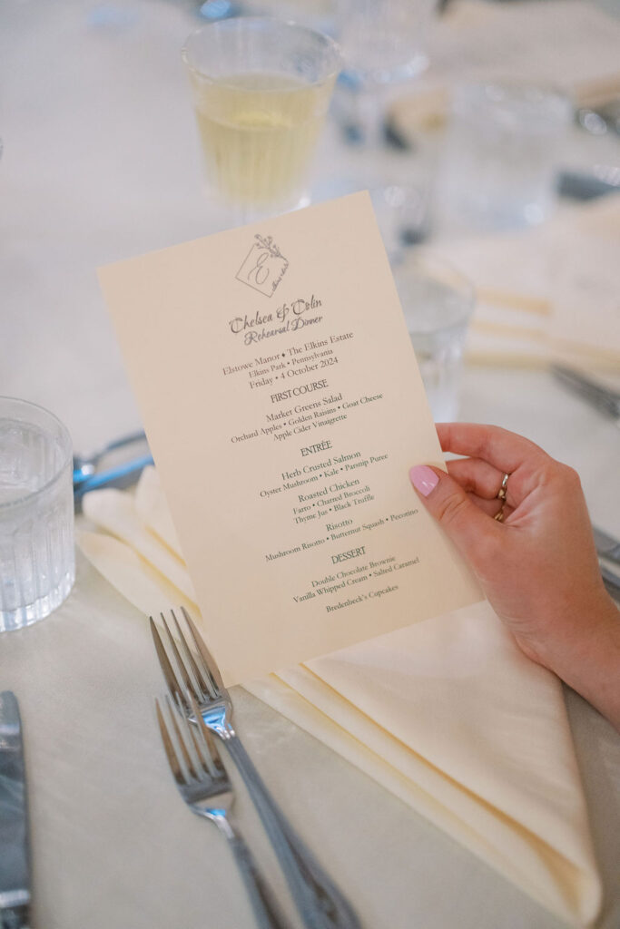 Bride holds rehearsal dinner menu | Lauren Bliss Photography at Elkins Estate in Philadelphia