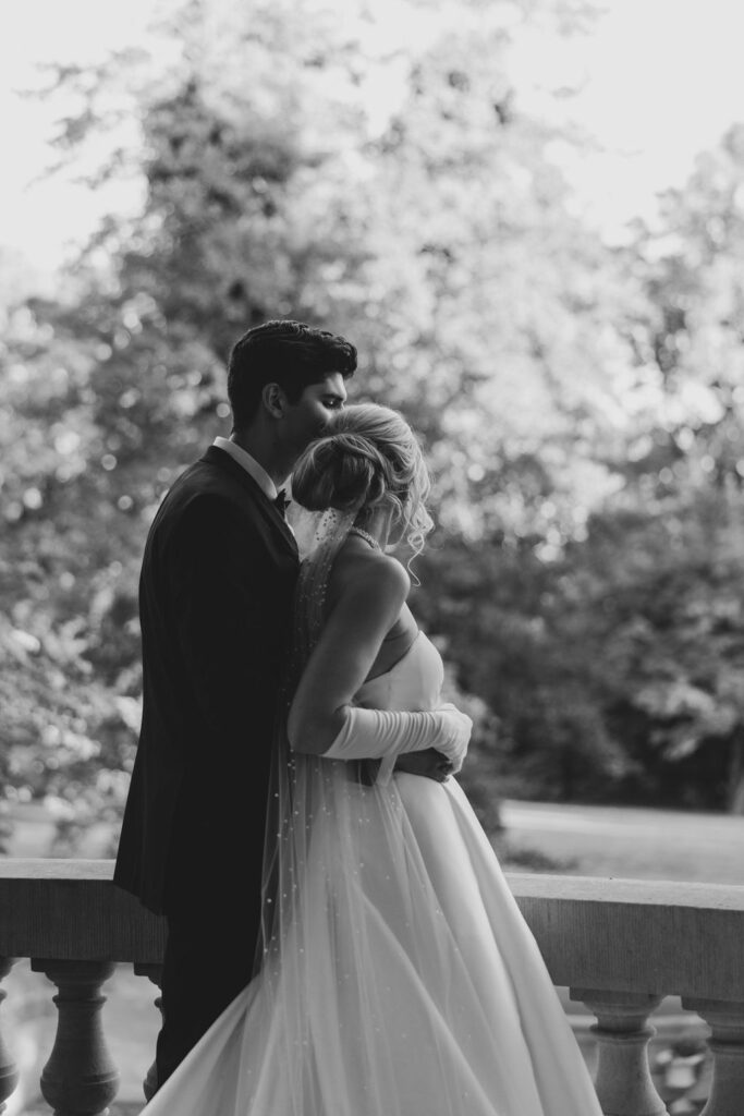 Groom stands behind bride holding her arms | Lauren Bliss Photography at Elkins Estate in Philadelphia