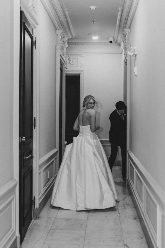 Bride and groom enter room at the end of a hallway | Lauren Bliss Photography at Elkins Estate in Philadelphia