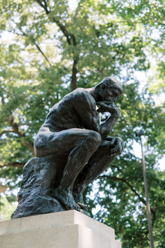 Auguste Rodin’s Bronze statue of The Thinker sits on a concrete pedestal in Philadelphia | Wedding Photography by Lauren Bliss at the Cescaphe Ballroom Philadelphia