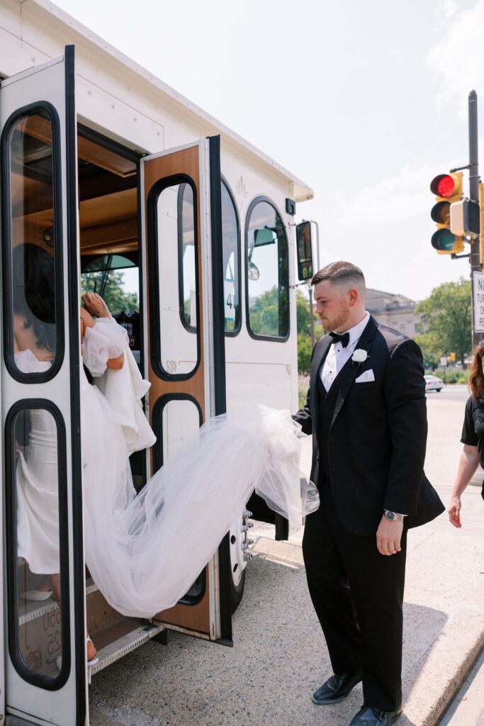 Groom helps bride step into parked shuttle | Wedding Photography by Lauren Bliss at the Cescaphe Ballroom Philadelphia