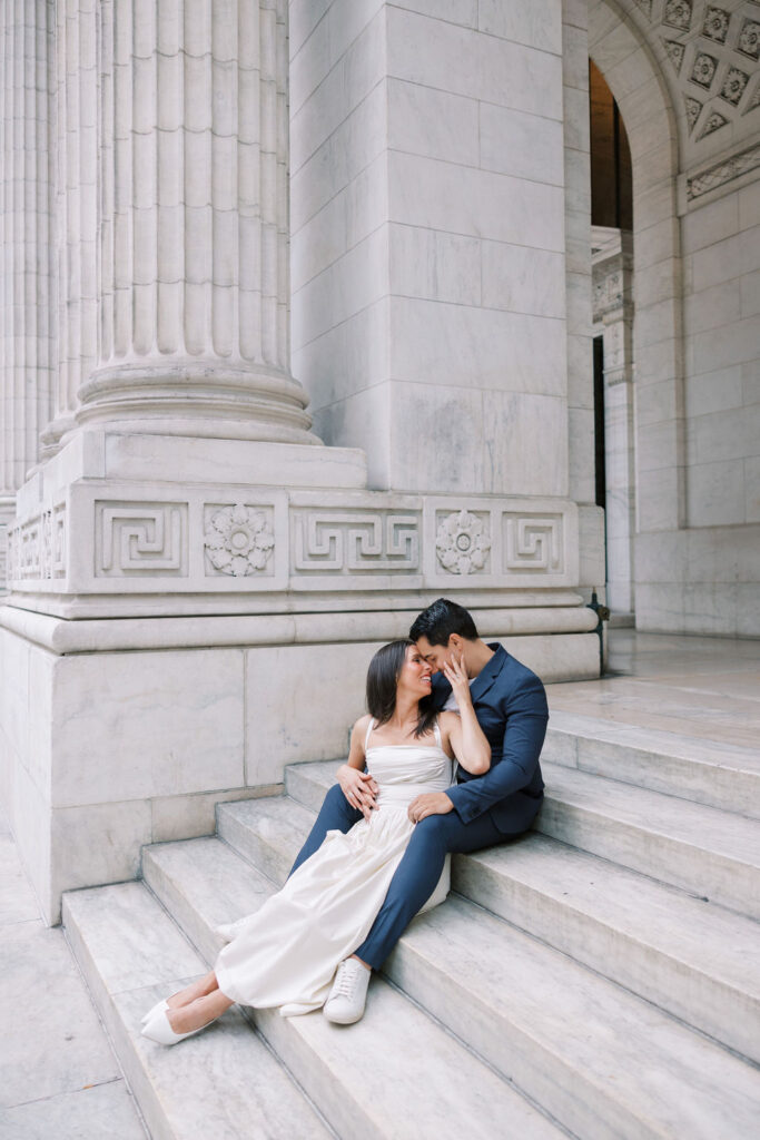 Couple sits on the marble staircase outside of the New York Public Library | Lauren Bliss Photography