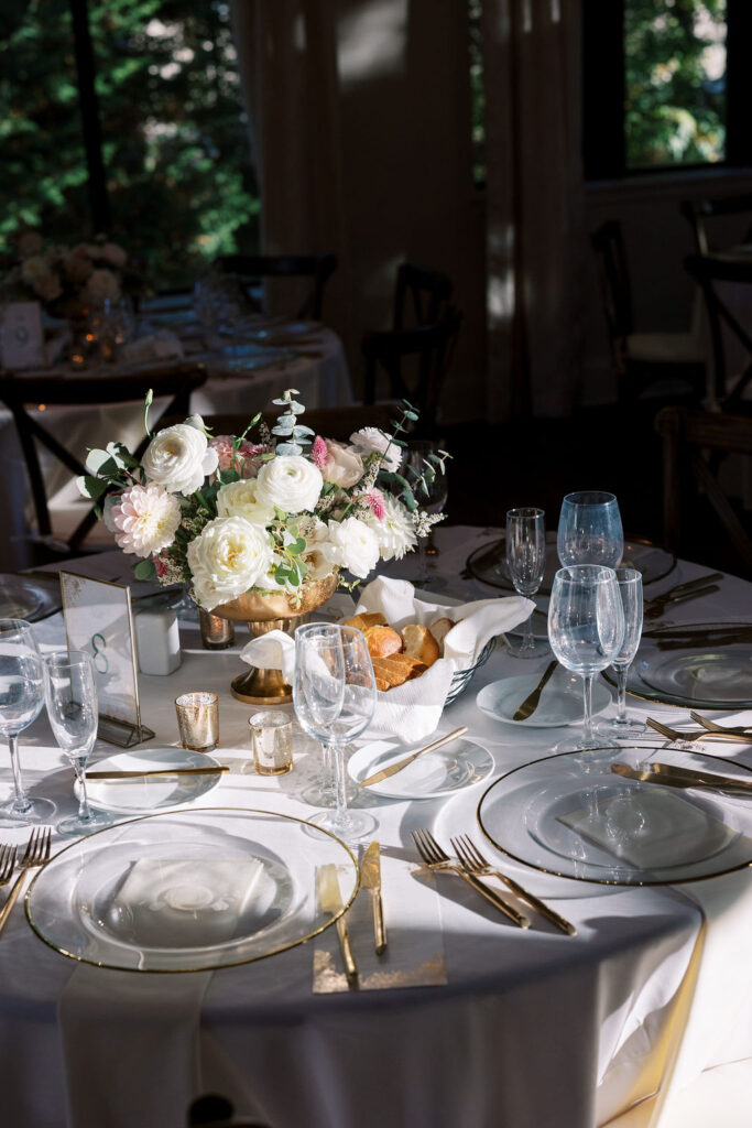 Table is set with gold and white flatware and dishes for a wedding at Aldie Mansion | Lauren Bliss Photography