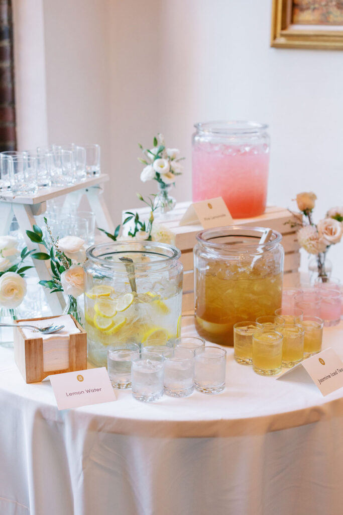 Table hold three pitchers of various drinks and drinking glasses during Aldie Mansion cocktail hour | Lauren Bliss Photography