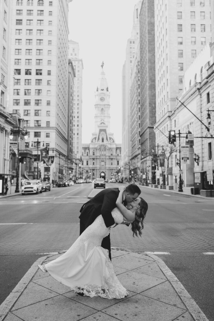 Groom dips bride to kiss her in front of city hall in downtown Philly | Lauren Bliss Wedding Photography in Philadelphia