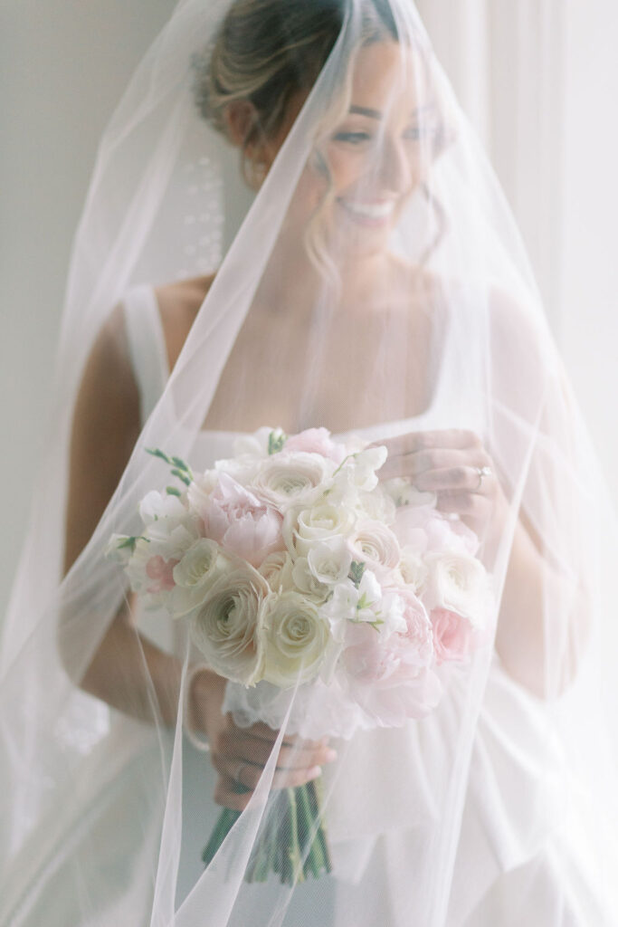 Bride holds pink and white bouquet and wears the Aire Barcelona gown from Bridal Garden