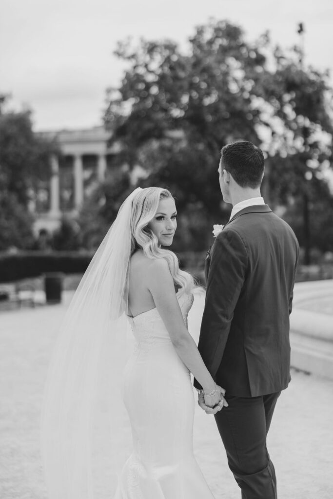 Bride and groom walk hand in hand in front of the Logan Fountain | Philadelphia Wedding at Waterworks Cescaphe by Lauren Bliss Photography
