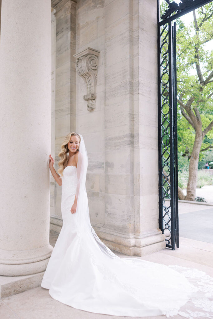 Bride stands next to large marble column in fit and flare wedding dress | Philadelphia Wedding at Waterworks Cescaphe by Lauren Bliss Photography