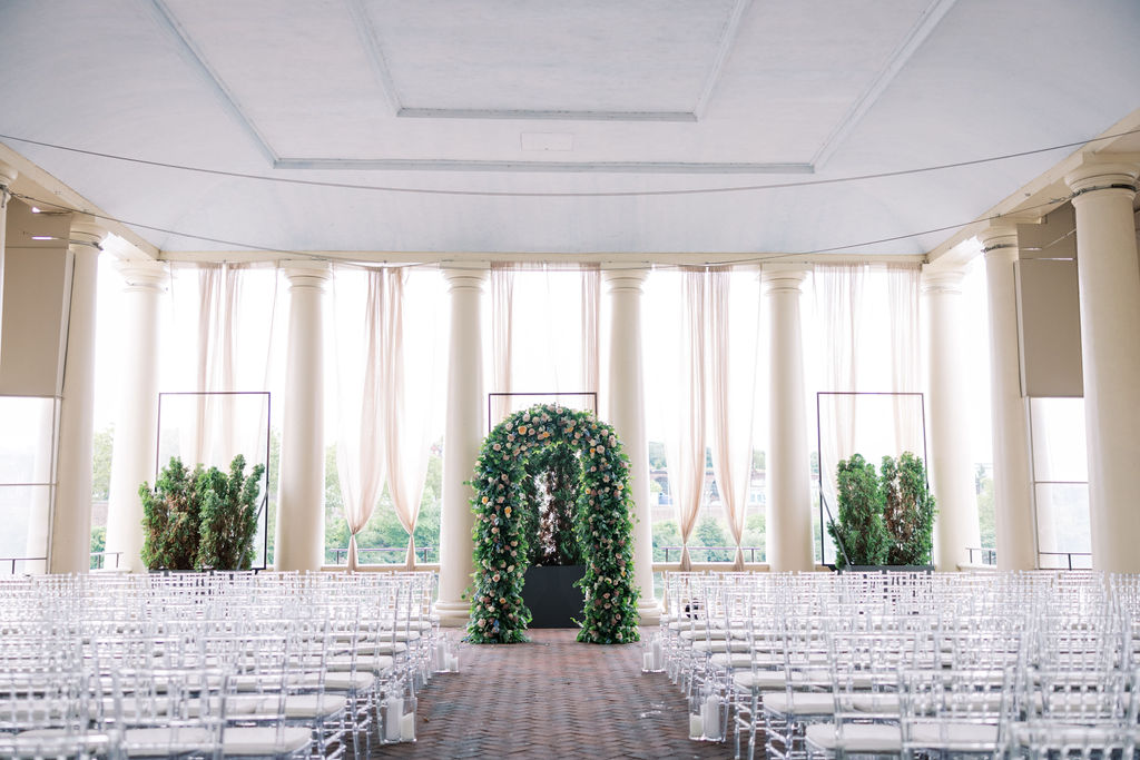Wedding ceremony space at Waterworks Philly is set up with acrylic chairs and floral arch | Philadelphia Wedding at Waterworks Cescaphe by Lauren Bliss Photography