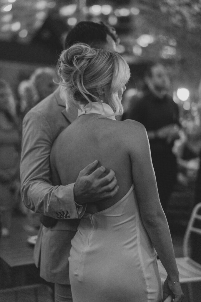 Woman in open back halter dress and modern french twist hairstyle | Philadelphia Wedding at Waterworks Cescaphe by Lauren Bliss Photography