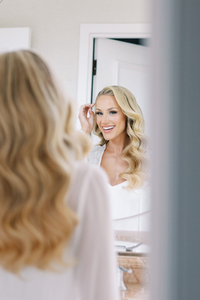 Bride admires glam waves hairstyle in mirror | Philadelphia Wedding at Waterworks Cescaphe by Lauren Bliss Photography