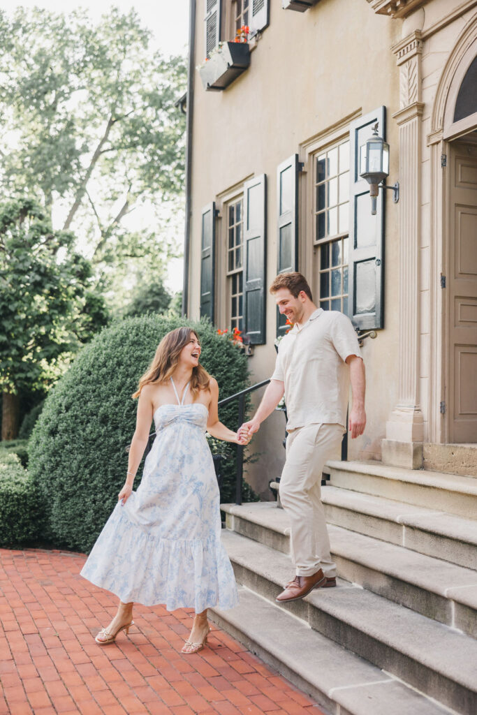 Couple wearing summery pastel engagement photo outfits poses during their session at Conestoga House in Lancaster PA | Lauren Bliss Photography