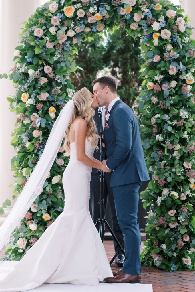 Bride and groom kiss in front of floral arch | Philadelphia Wedding at Waterworks Cescaphe by Lauren Bliss Photography