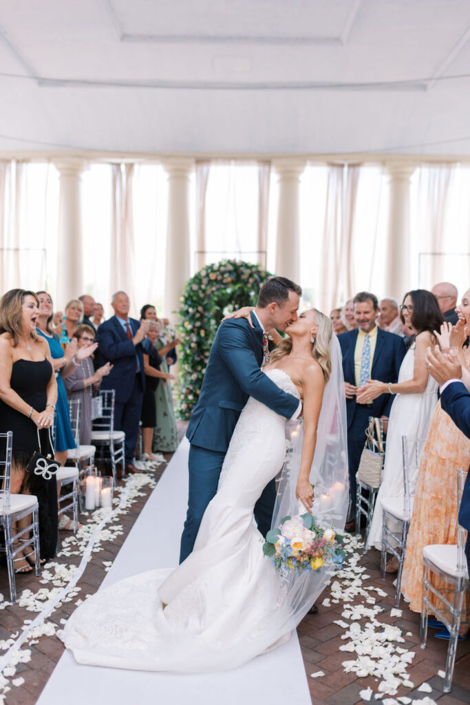 Bride and groom kiss in the wedding ceremony aisle at Waterworks Philly | Philadelphia Wedding at Waterworks Cescaphe by Lauren Bliss Photography