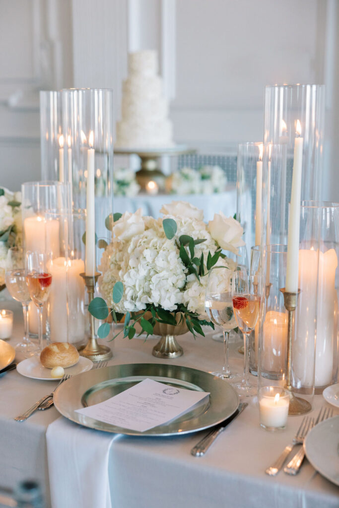 White hydrangea wedding floral centerpiece surrounded by pillar candles in the Cescaphe Down Town Club venues in Philadelphia