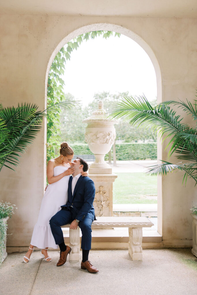 Romantic Longwood Gardens engagement photo of a couple on a stone bench gazing into each others eyes captured by Lauren Bliss Photography, perfect for a chic save-the-date card