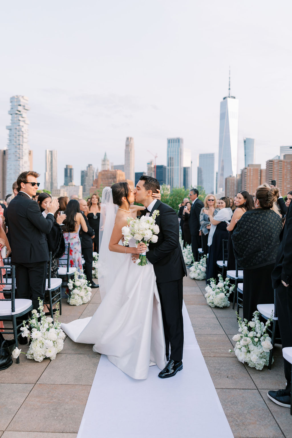Bride and groom share a kiss after their rooftop ceremony at Tribeca 360, captured by Lauren Bliss Photo in Manhattan with NYC skyline views.