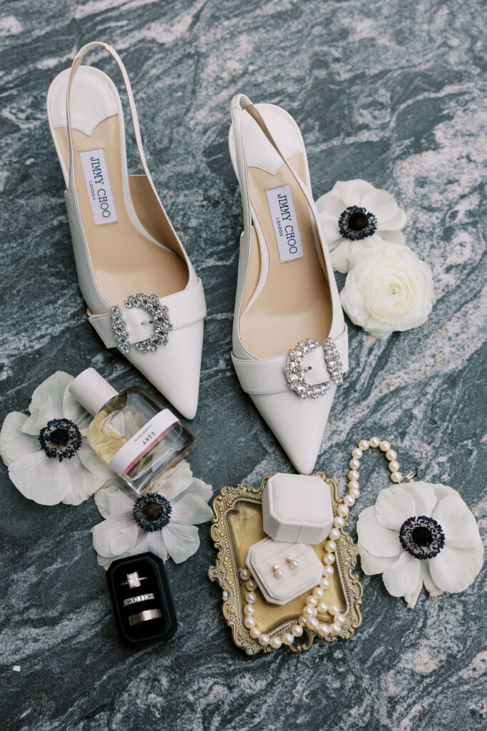 Elegant bridal details featuring Jimmy Choo heels, pearl jewelry, wedding rings, and flowers, styled at Tribeca 360 in New York City for Sam and Andrew’s wedding.