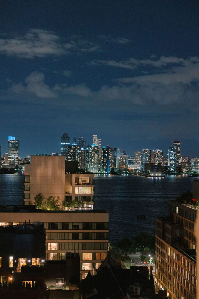 Romantic night view of the New York City skyline overlooking the Hudson River, captured from Tribeca Rooftop wedding venue by Lauren Bliss Photography.