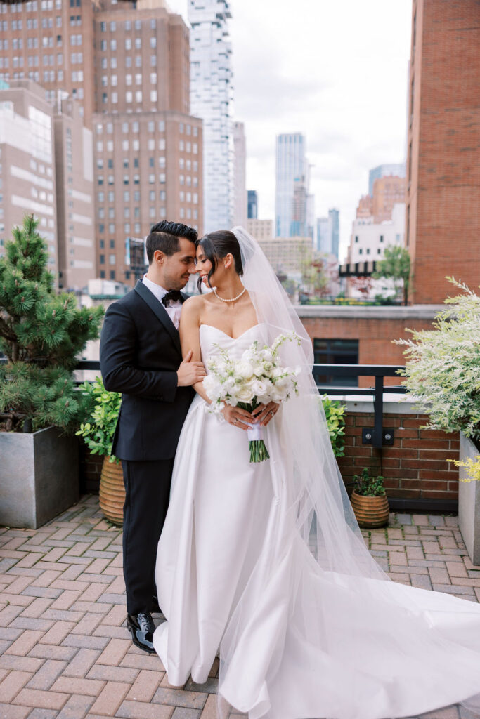 Bride and groom stand on stone patio at Tribeca Rooftop venue in NYC photographed by Lauren Bliss Photography