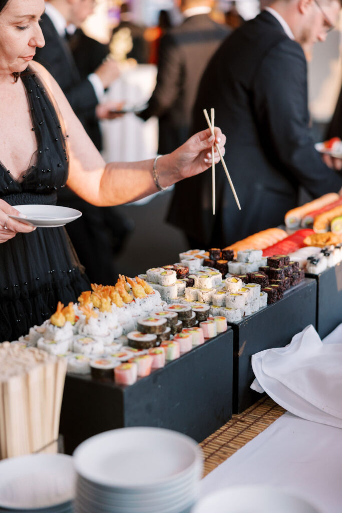 Guest serving from a colorful sushi display during cocktail hour at Tribeca Rooftop wedding in New York City.