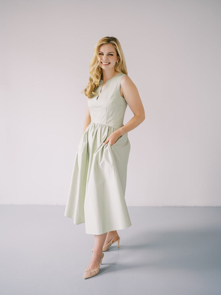 Sophisticated and playful full-body portrait of Lauren in a sage green midi dress, part of Lauren Bliss Photography team branding session in NYC