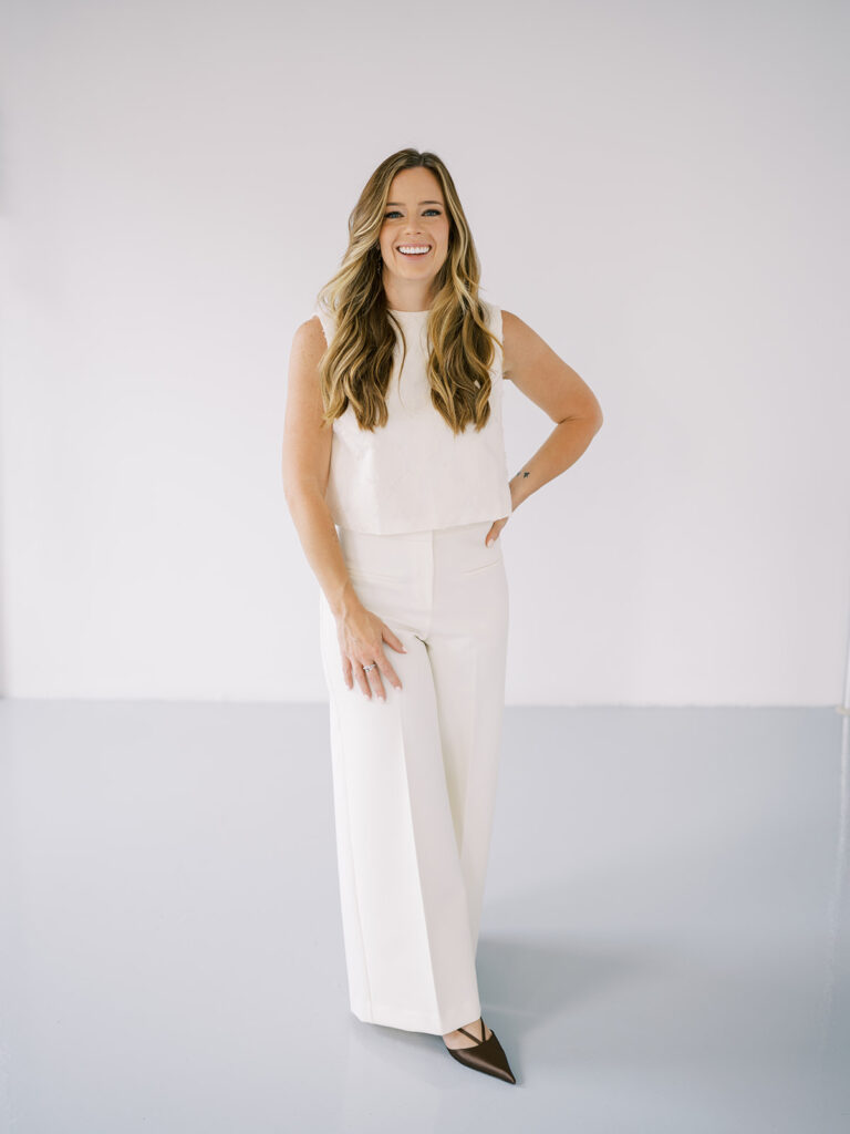 Bright and professional branding portrait of Sarah, associate photographer at Lauren Bliss Photography, wearing all white in NYC studio