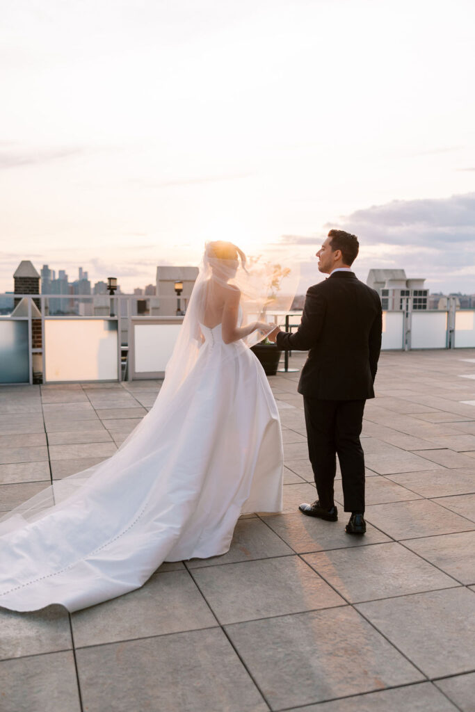 Bride and groom walking at sunset on rooftop in NYC during elegant wedding at Tribeca Rooftop, captured by Lauren Bliss Photography