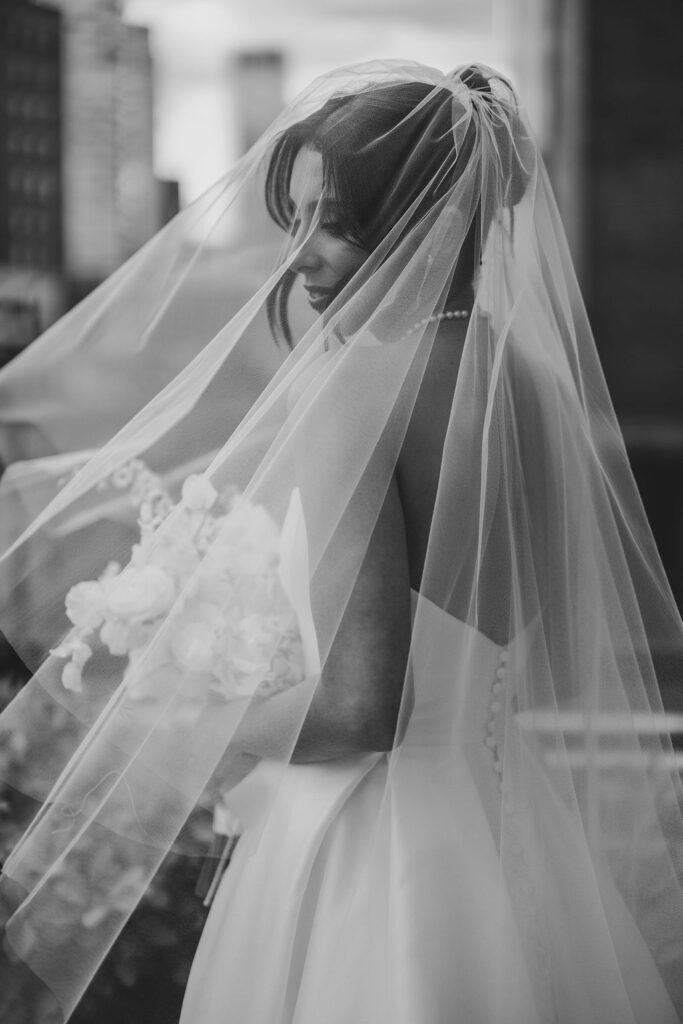 Elegant black and white bridal portrait with veil softly covering her face at Tribeca Rooftop wedding in NYC, captured by Lauren Bliss Photography.