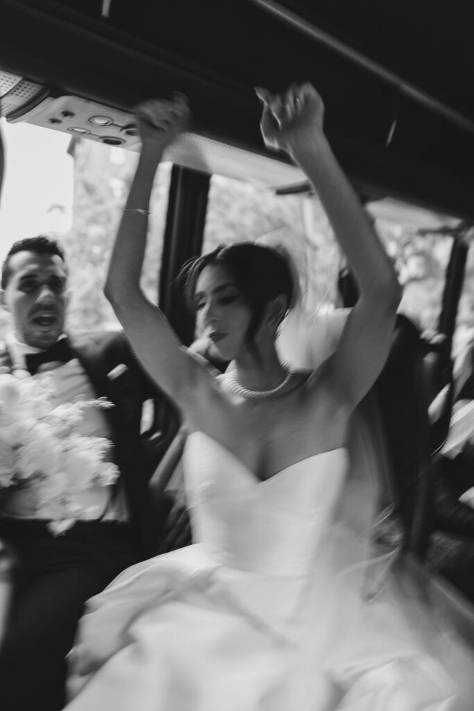 Bride and groom celebrating on the wedding bus ride to Tribeca Rooftop in New York City, photographed by Lauren Bliss Photography.