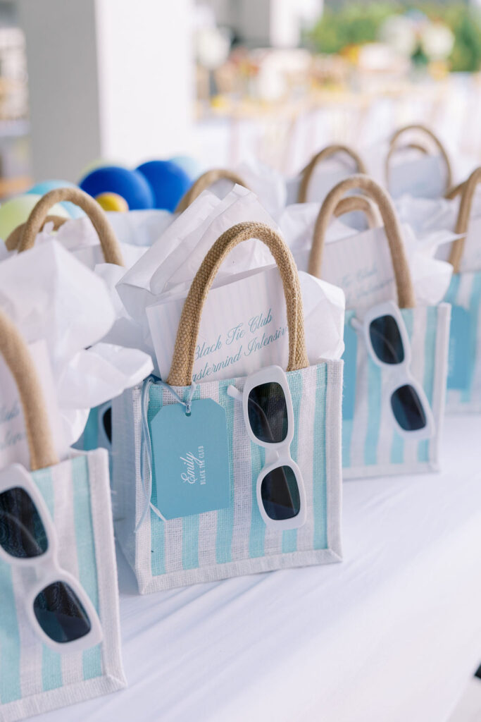 Striped welcome bags with sunglasses and retreat materials styled for guests attending a luxury 30A beach retreat.