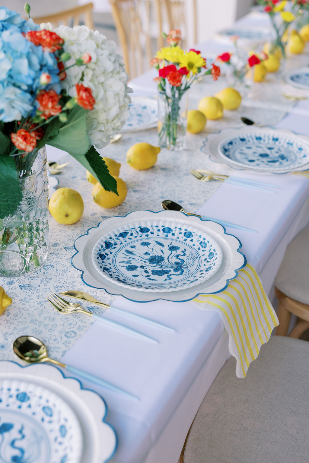 Close-up detail of lemon-lined coastal event table decor with blue patterned plates at a 30A beach retreat.