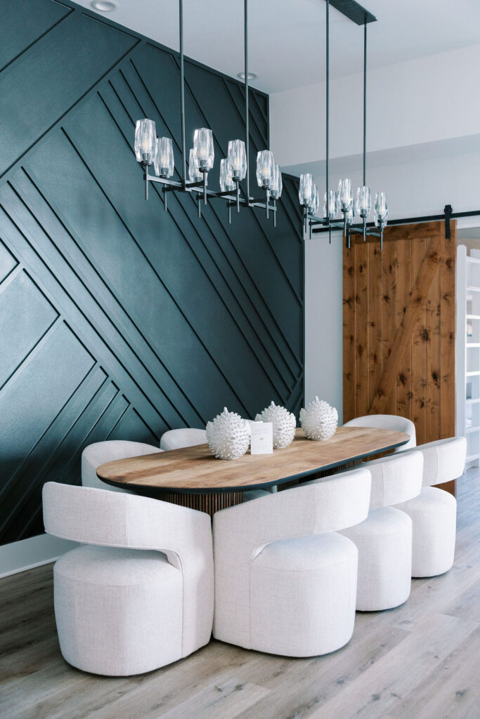 Modern dining room with geometric accent wall, sculptural seating, and coastal event decor inside a luxury 30A beach retreat.