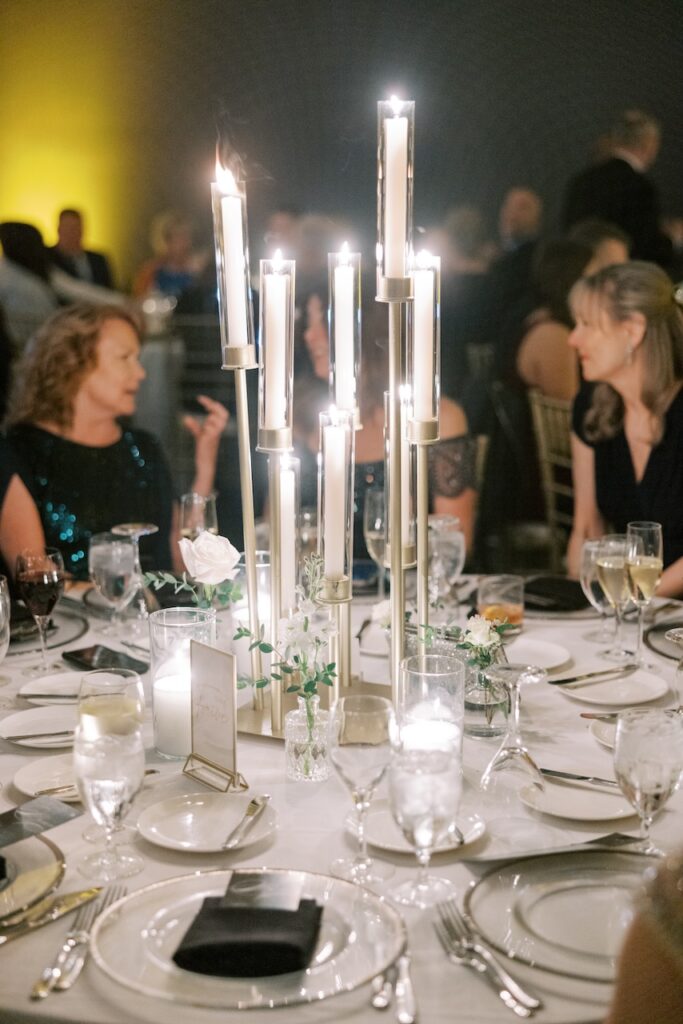Tall candlelit centerpieces and elegant table settings at a Philadelphia wedding reception at The Logan Hotel, captured by Lauren Bliss Photography for a Philadelphia Area Venue Guide