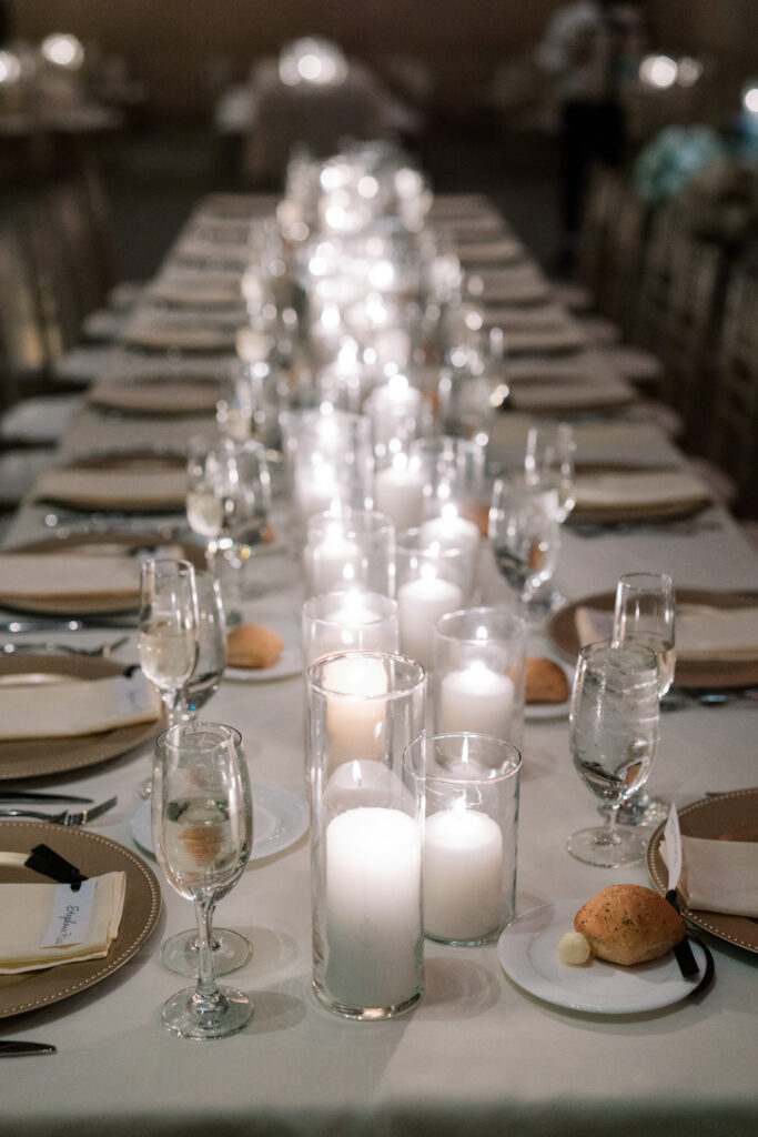 Long candlelit reception table at Union Trust with glowing pillar candles, champagne flutes, and elegant place settings, photographed by Lauren Bliss Photography.