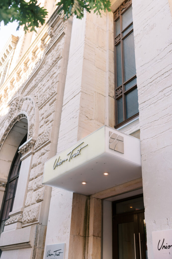 Exterior entrance of Union Trust in Philadelphia featuring the illuminated marquee sign and historic architectural details, photographed for a luxury Philadelphia area venue guide by Lauren Bliss Photography.
