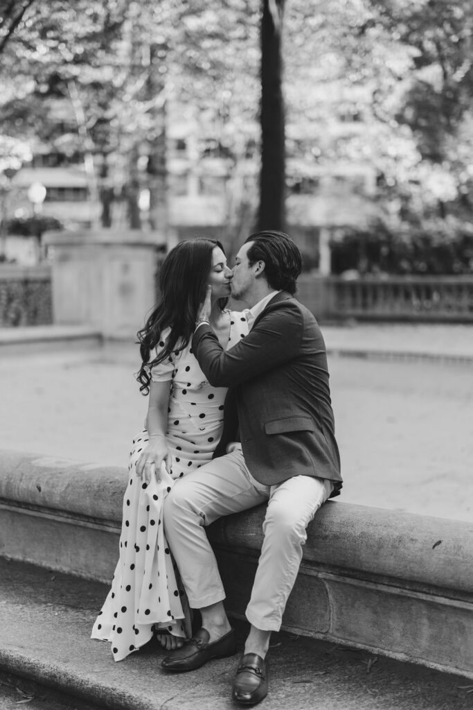 Couple kisses during Rittenhouse Square fountain golden hour Philadelphia engagement session