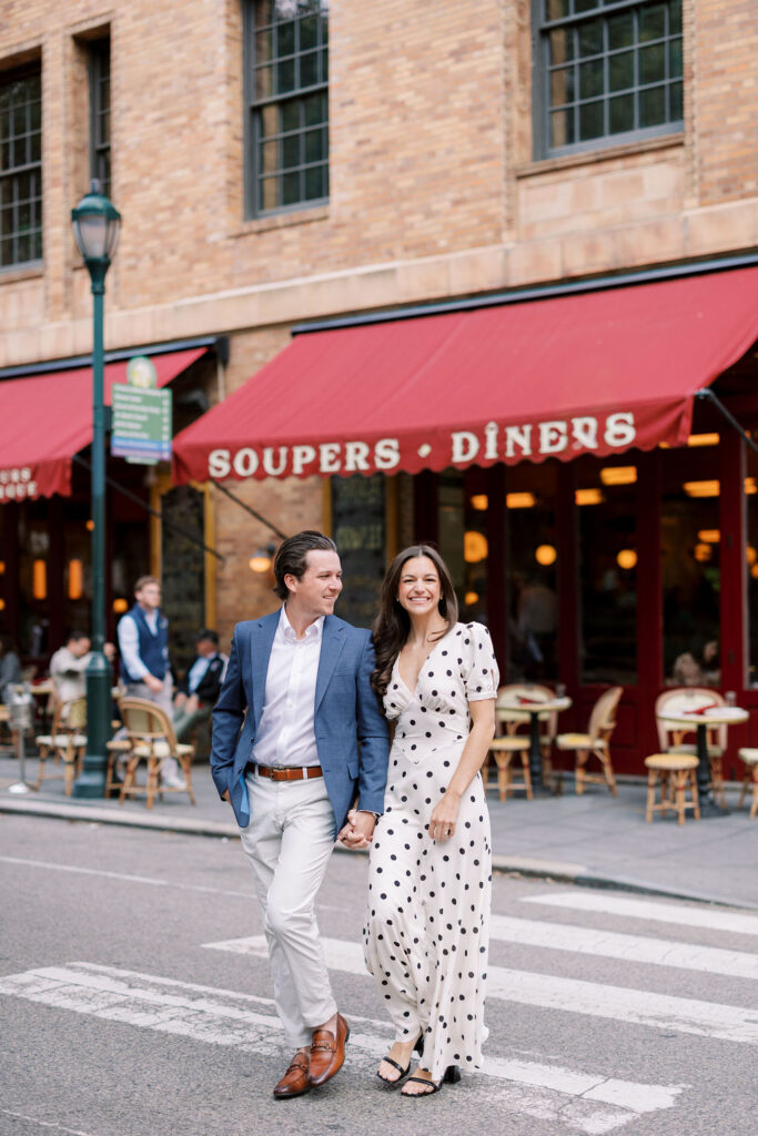 Haley and Griffin crossing street in front of Parc French bistro during fall Philadelphia engagement session