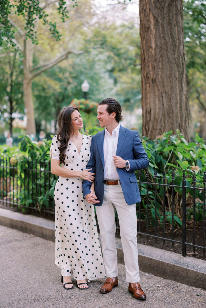 Haley and Griffin hold hand in front of the iron fencing around Rittenhouse Square park in Philadelphia