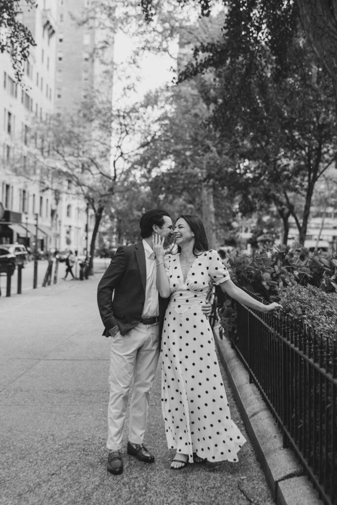 Joyful photo of couple laughing while walking the sidewalk around Rittenhouse Square park in Philadelphia