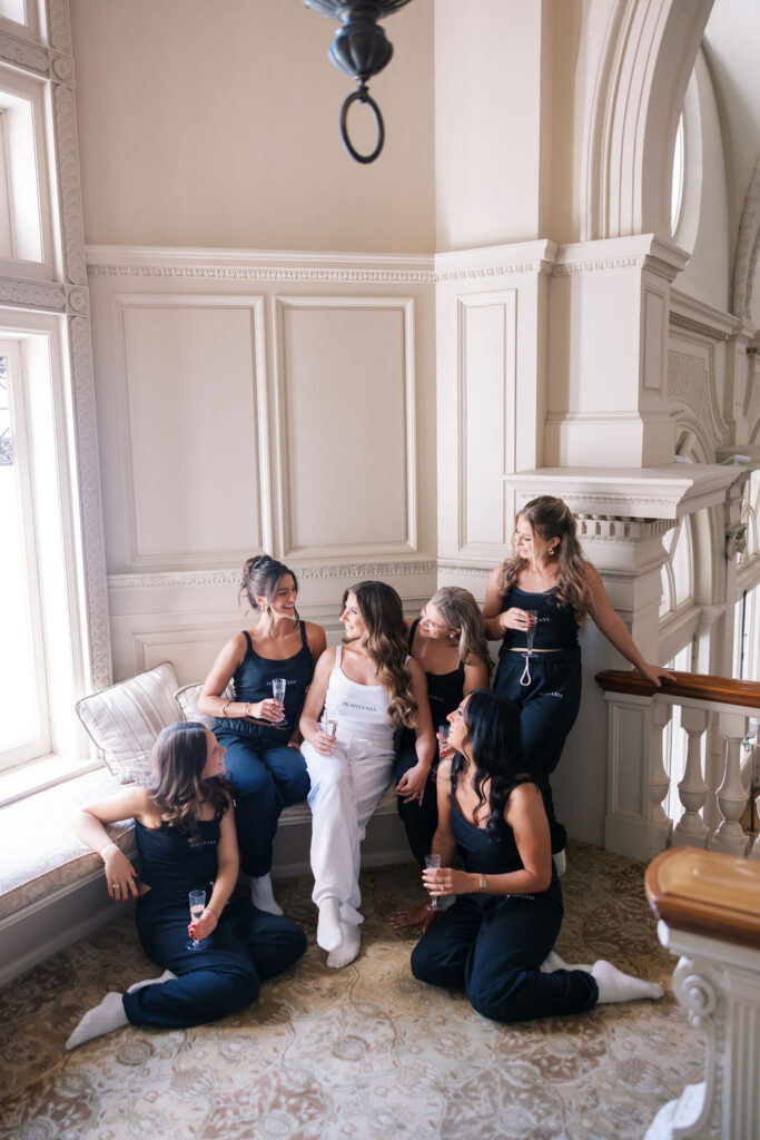 Bride and bridesmaids in matching loungewear sipping champagne at Cairnwood Estate