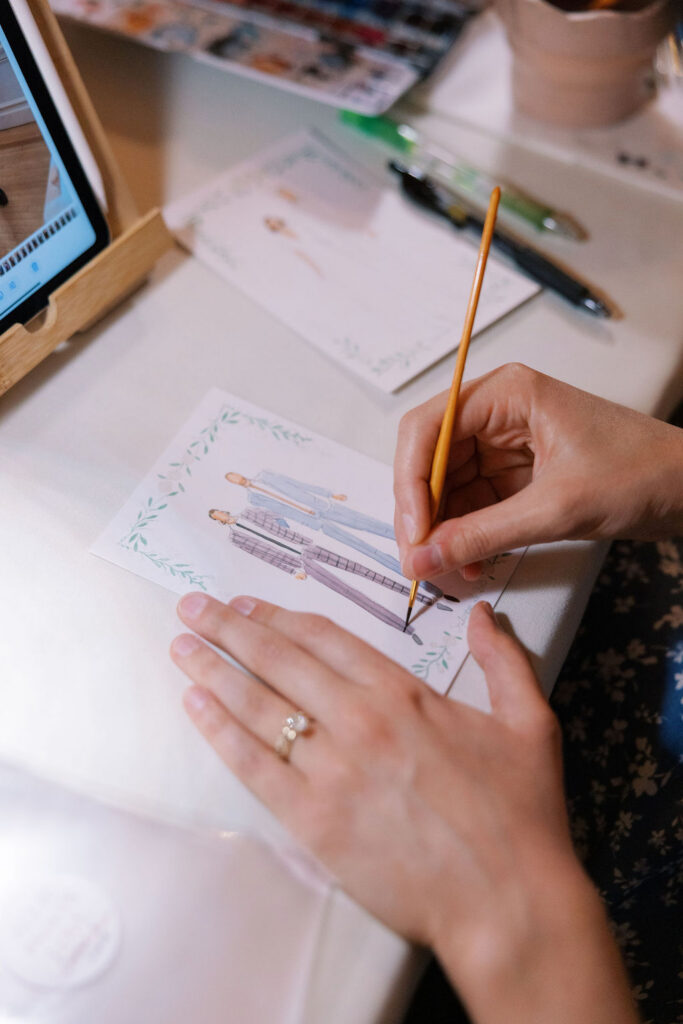 Artist painting a live fashion illustration of guests at a wedding
